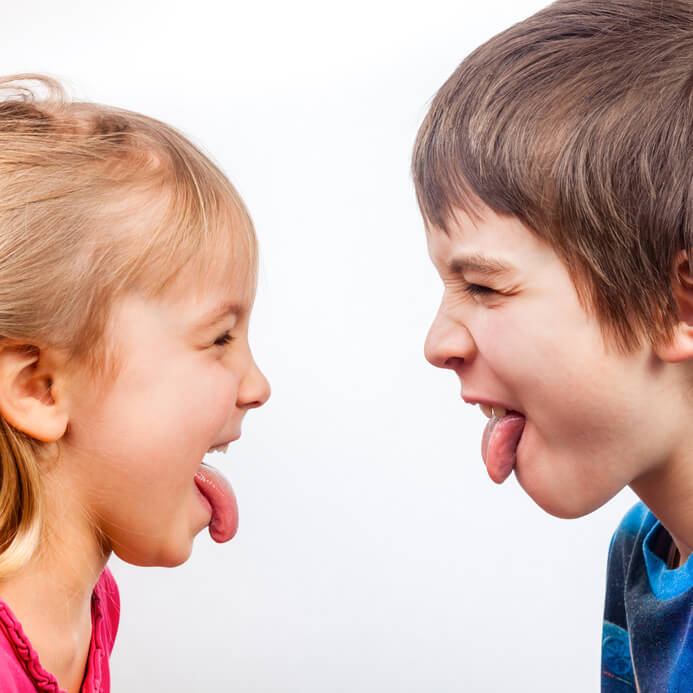 Zwei Kinder, die sich die Zunge heraus strecken